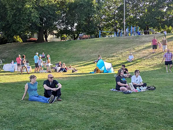 BBQ attendees sitting in park
